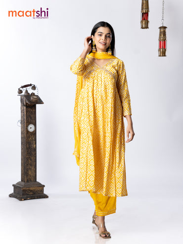 Muslin readymade alia cut salwar suit yellow and off white with allover ikat prints & embroidery mirror work neck pattern and straight cut pant & chiffon dupatta